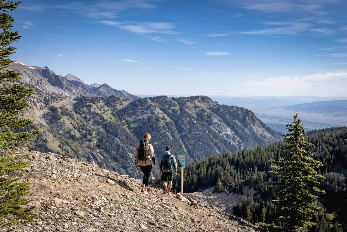 Two hikers with mountain views on the North Ridge Trail