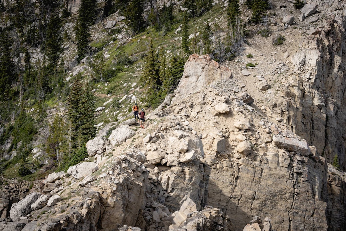 Two hikers approaching a cliff on the North Ridge Trail