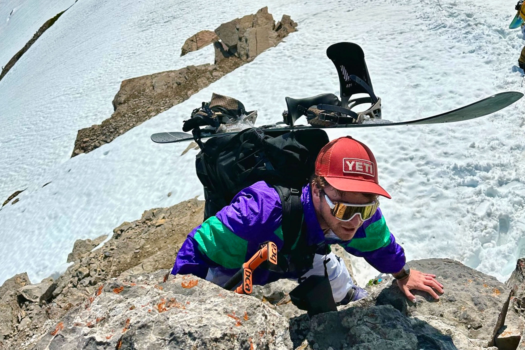 a snowboarder climbing up Cody Peak