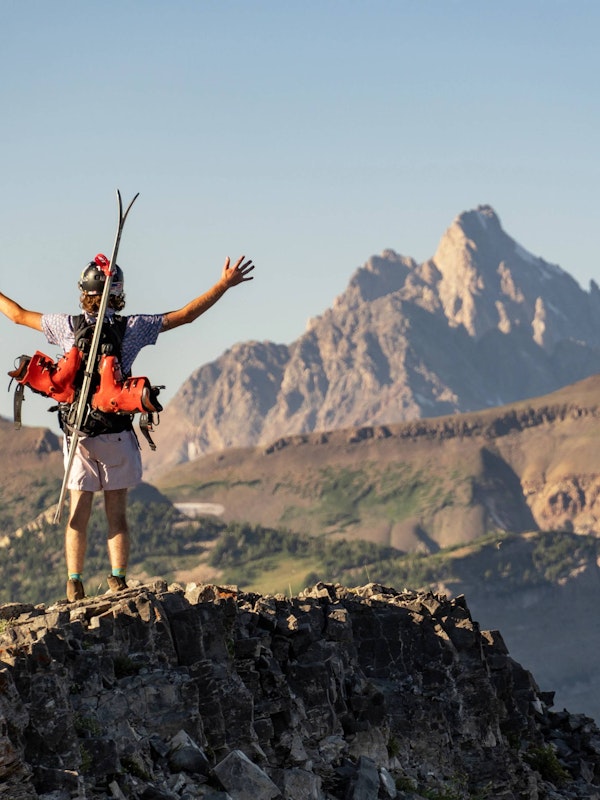 A skier looking out towards the Grand Teton in the summer