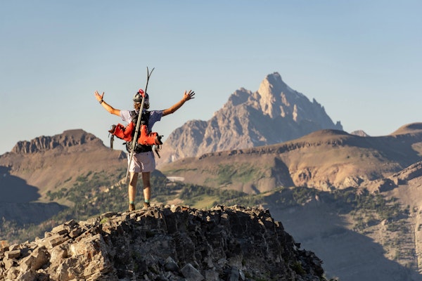 A skier looking out towards the Grand Teton in the summer