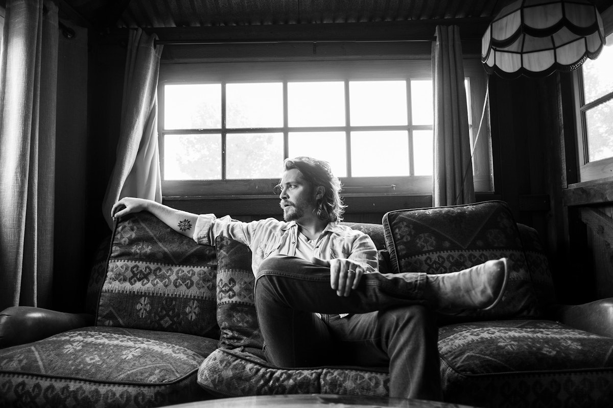 Luke Grimes sitting on a couch