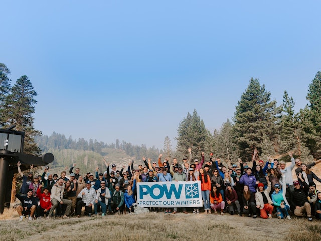 a crowd holding a POW banner