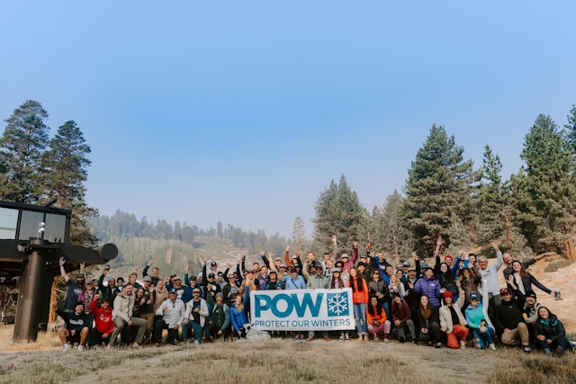 a crowd holding a POW banner