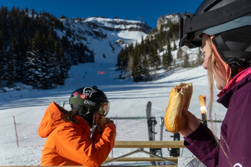 Two women eating a Bear Dog on the mountain