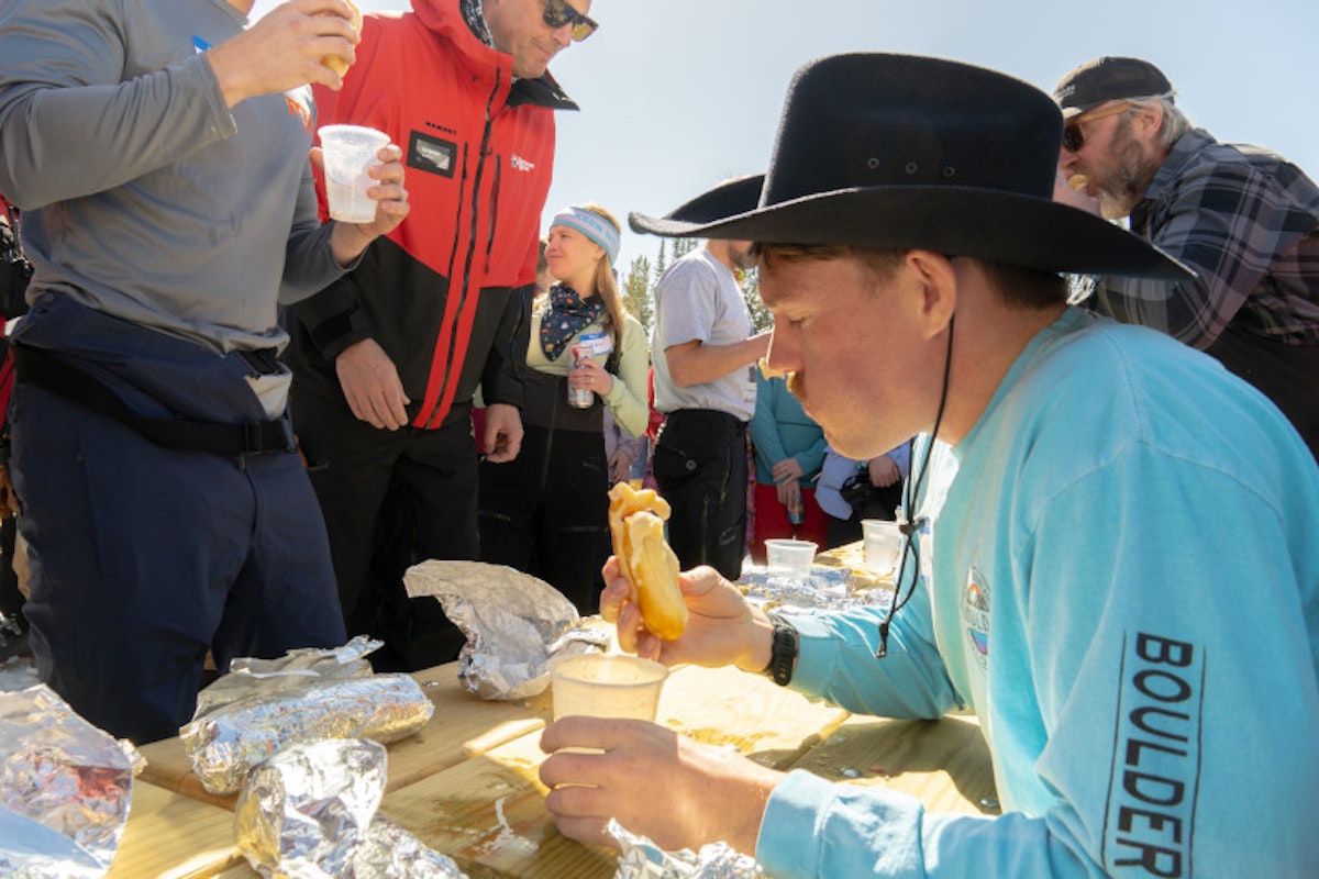 Cowboy hat man eating a bear dog