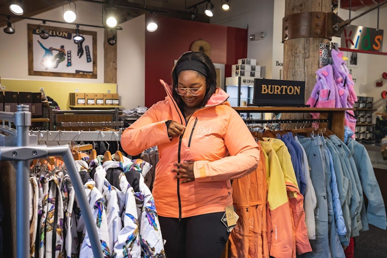 person trying on jacket at JH Sports