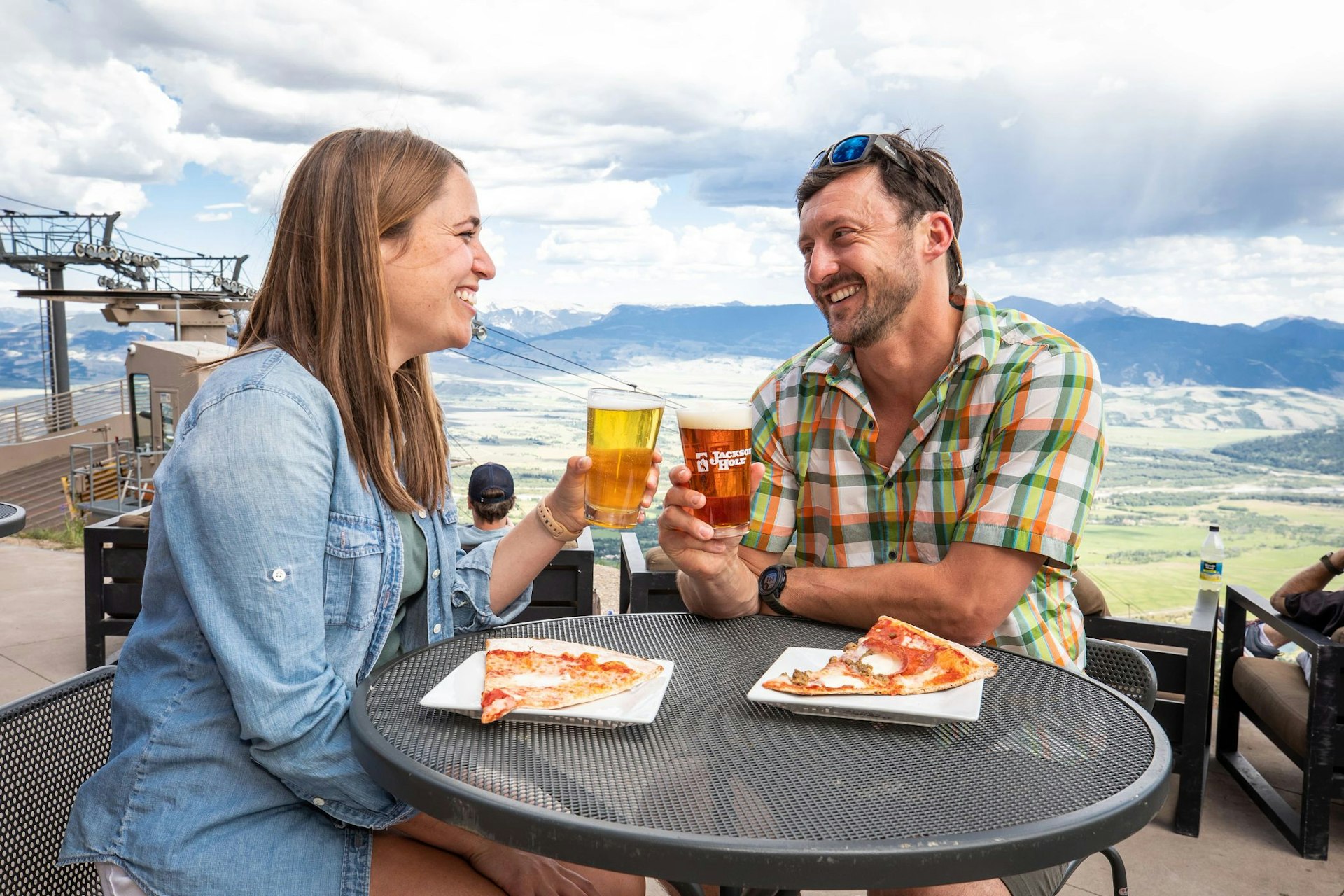 Man and woman having beer and pizza at The Deck