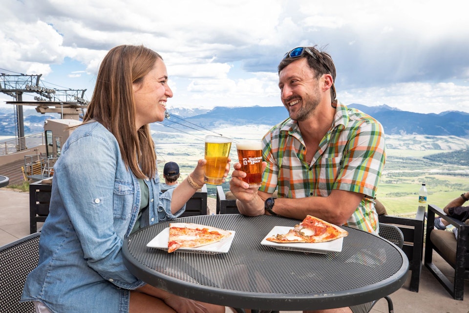 Man and woman having beer and pizza at The Deck