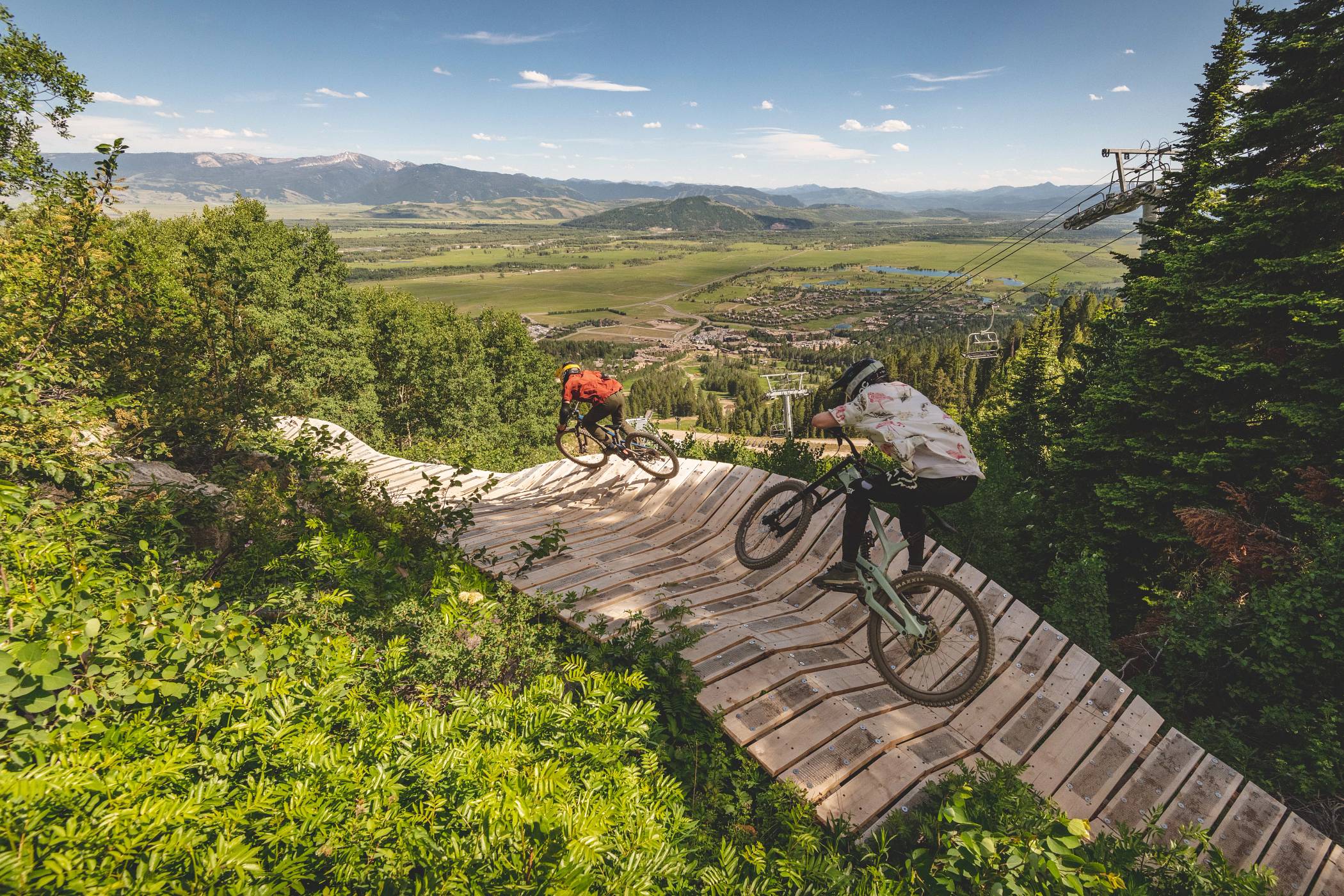 Two bikers on a wooden feature in the JH Bike Park