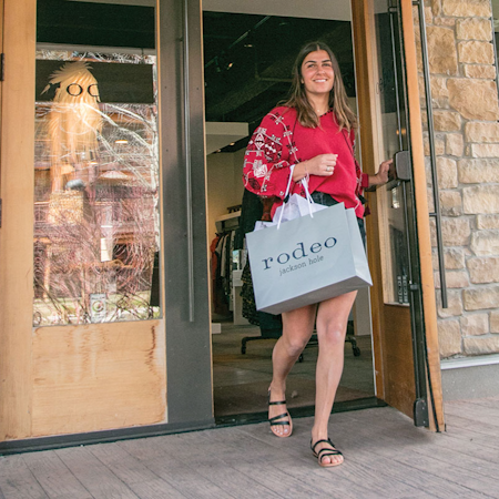 Woman walking out of Rodeo with shopping bag