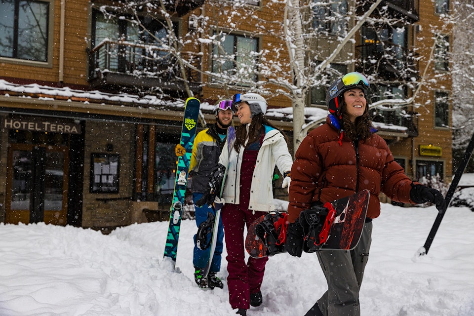 Skier and snowboarders walking out of Hotel Terra