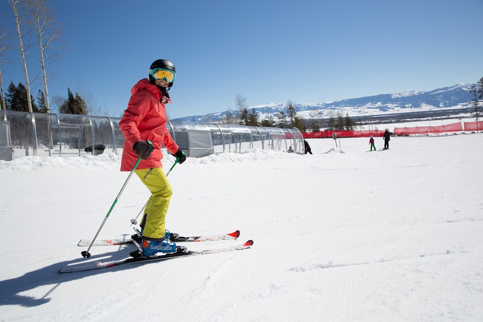 Beginner skiier skiing off of the magic carpet