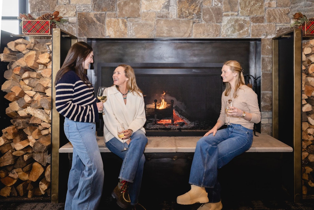 Women sitting at fireplace at Trapper's