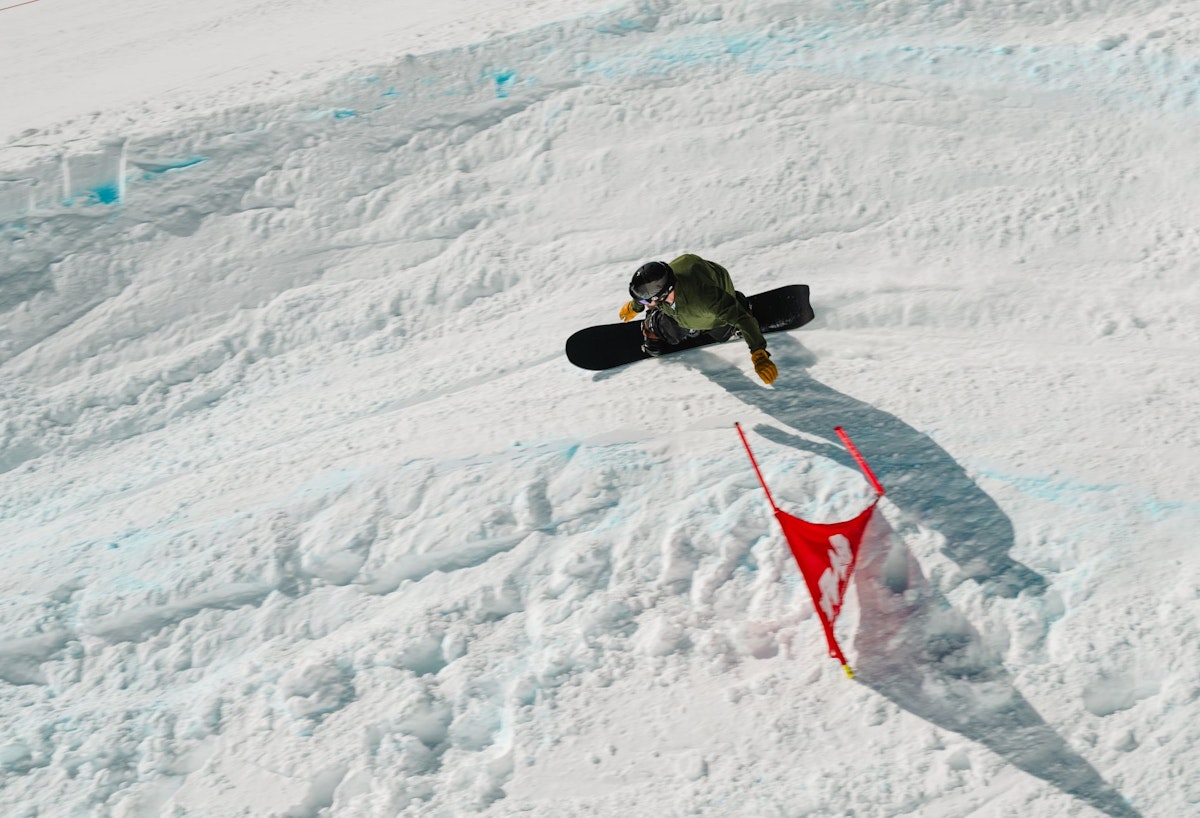 Snowboarder turning around gate in Dick's Ditch