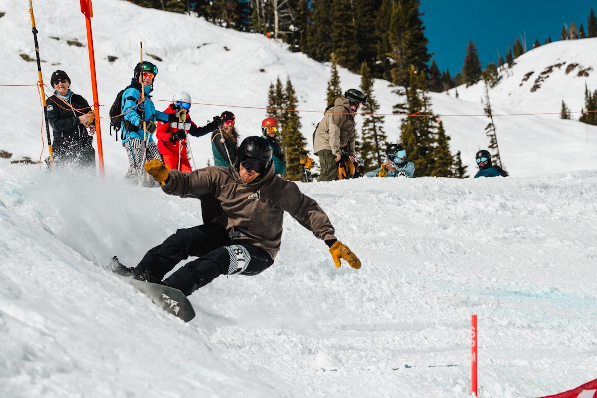 Snowboarder turning around gate in Dick's Ditch