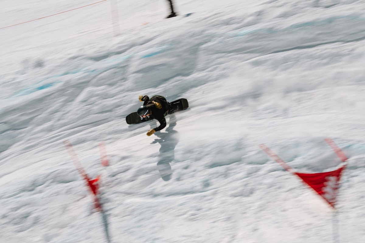 Snowboarder turning around gate in Dick's Ditch
