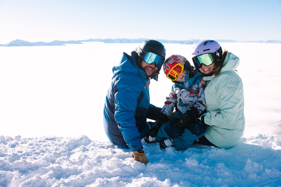Family on top of Jackson Hole Mountain Resort on a bluebird day with inversion layer in the valley