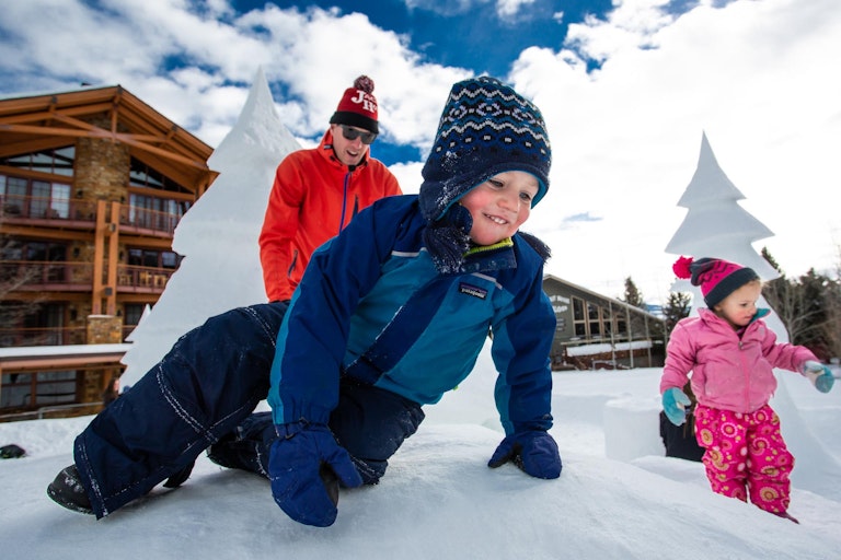 kids playing on ice castle in teton village, wy
