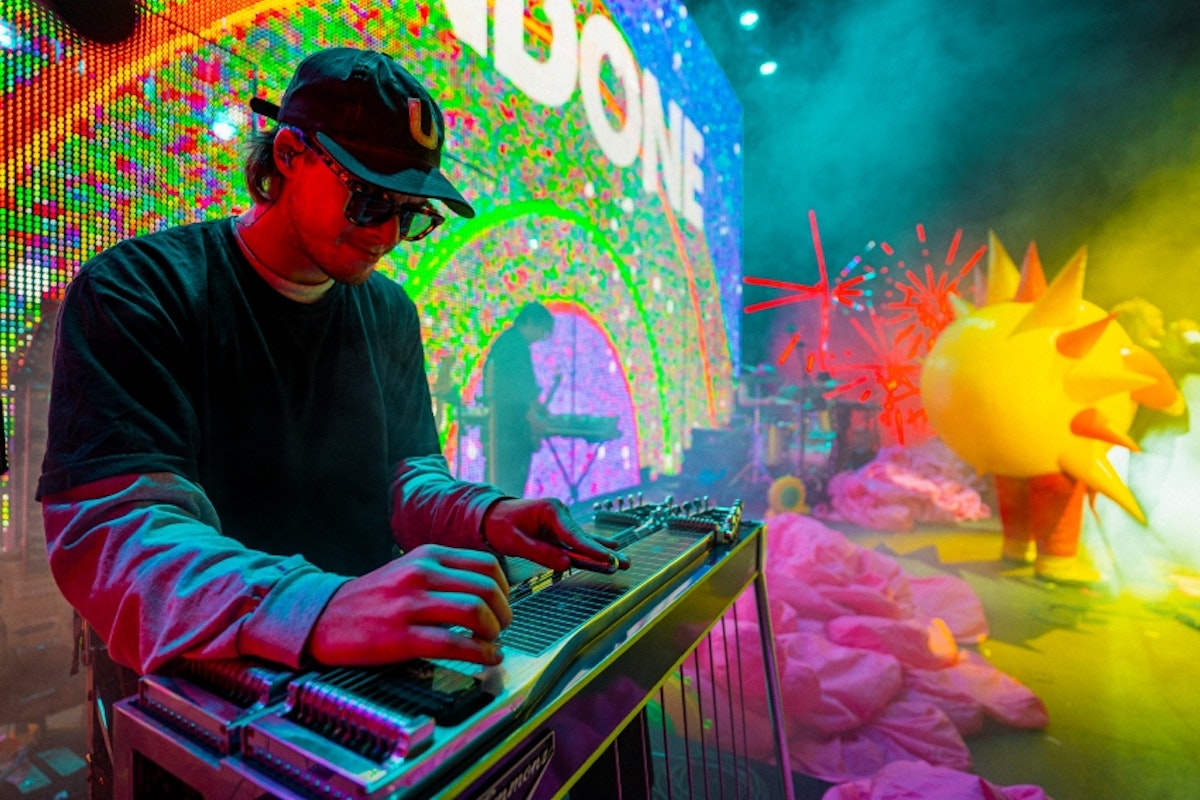 Flaming Lips steel guitar player performing live, colorful background