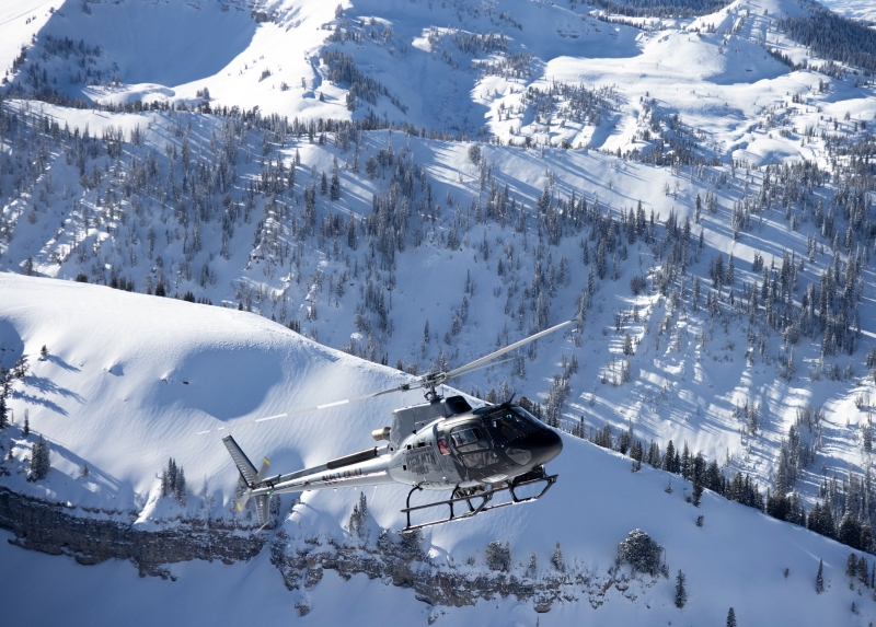 helicopter flying in front of the tetons