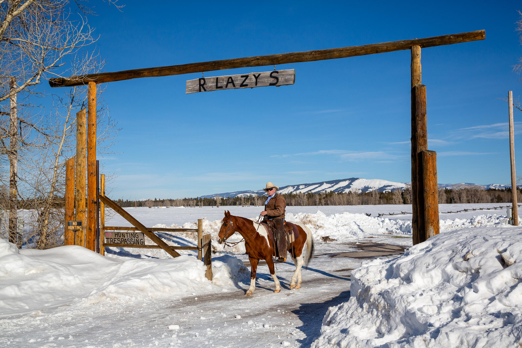 Cowboy on horse under ranch enterance
