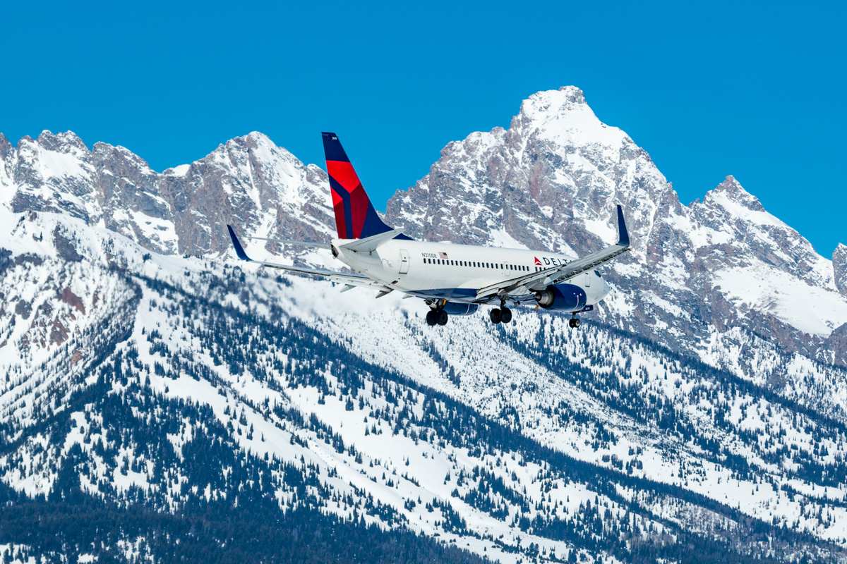 Delta plane flying in front of the Tetons