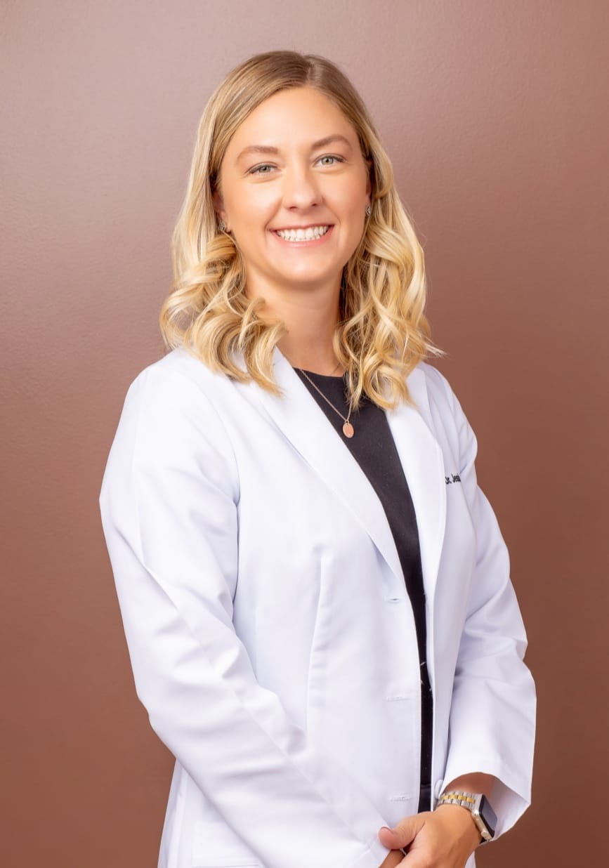 Dr. Jessica Arneson, a top Podiatrist in Newport Beach, Smiling And Wearing White Doctor's Coat.
