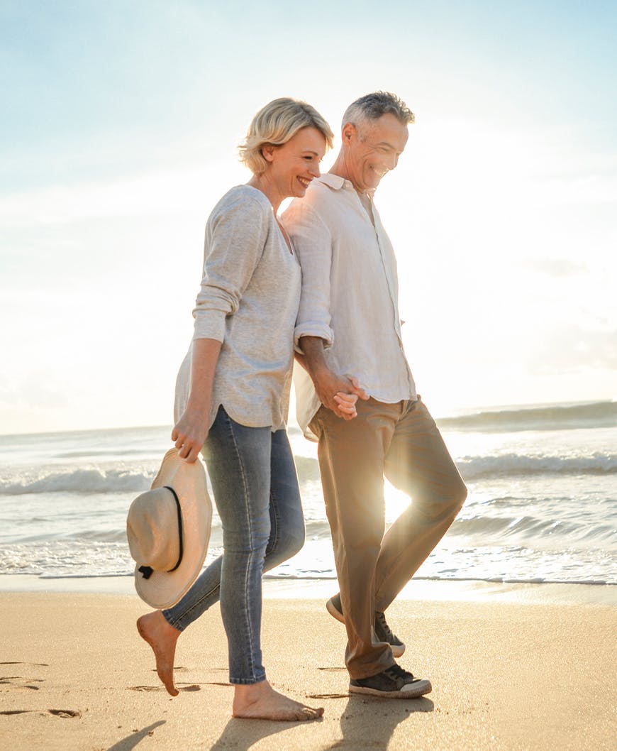 Husband And Wife Walking Together On The Sand After Surgical Flat Foot Correction In Newport Beach.