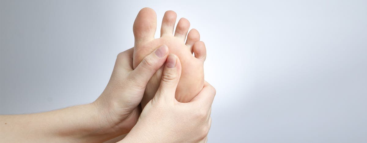 an image of a woman grasping the bottom of a foot