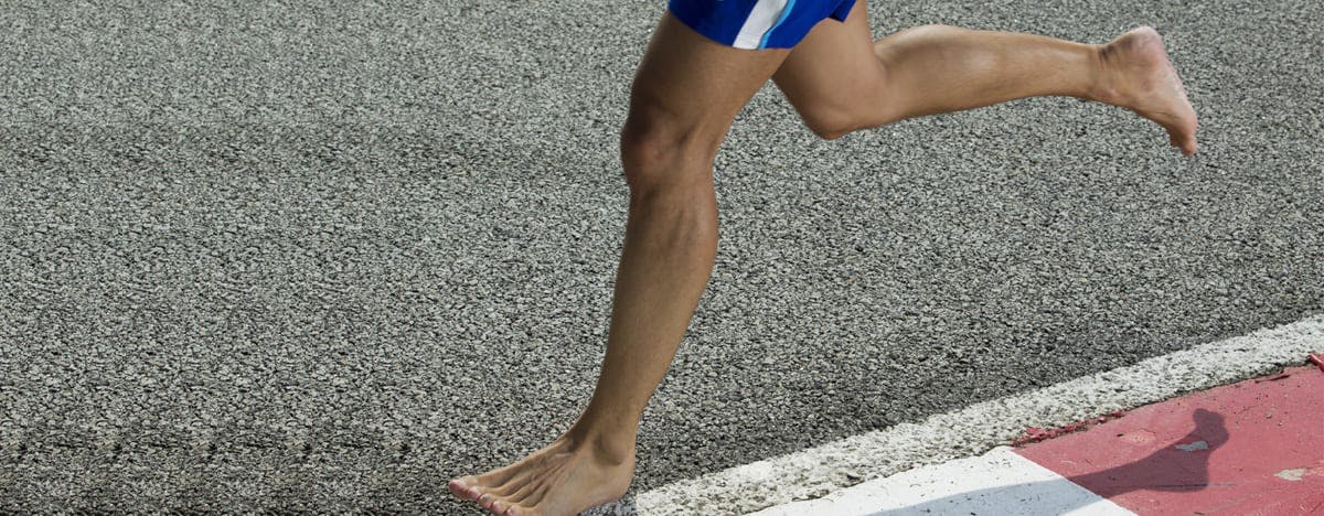 a close up of a barefoot runner