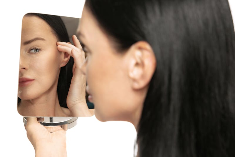 woman looking at her reflection in the mirror