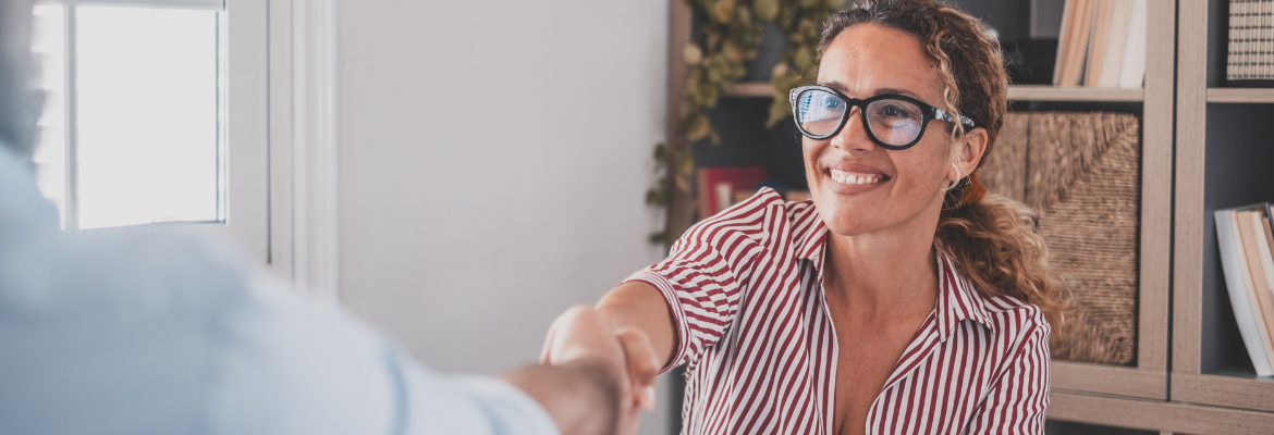 femme qui sert la main de son employeur après la signature de son contrat