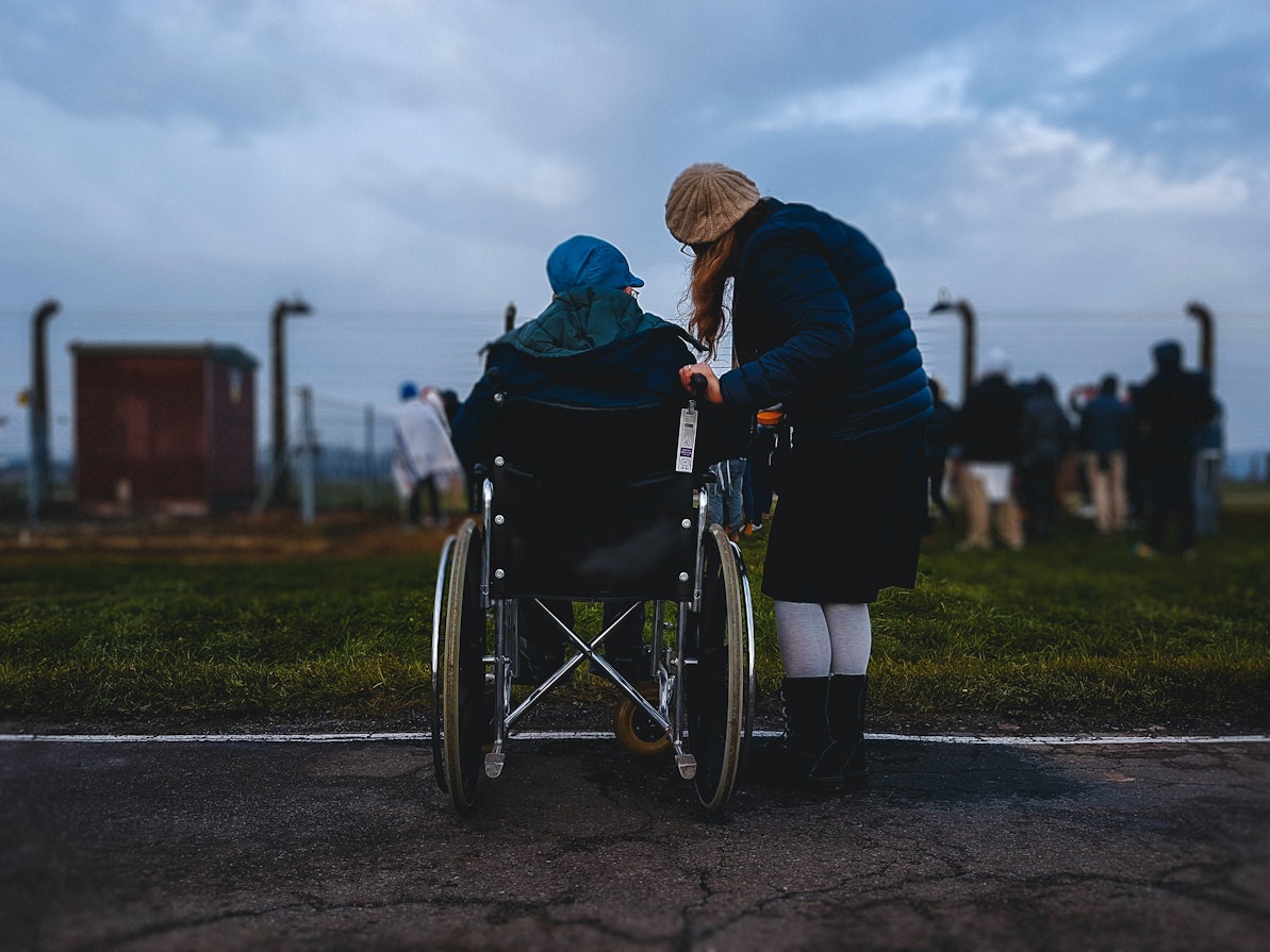 Deux personnes de dos dont une en fauteuil roulant