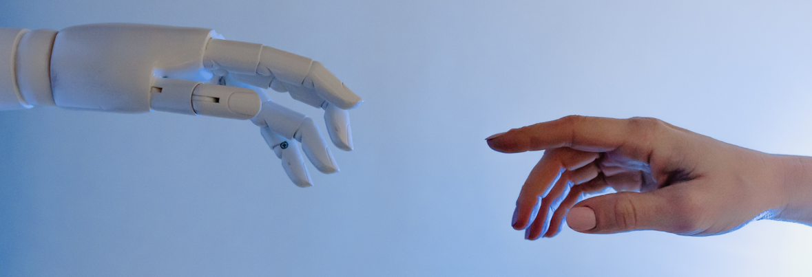 Main de robot qui se dirige vers une main humaine