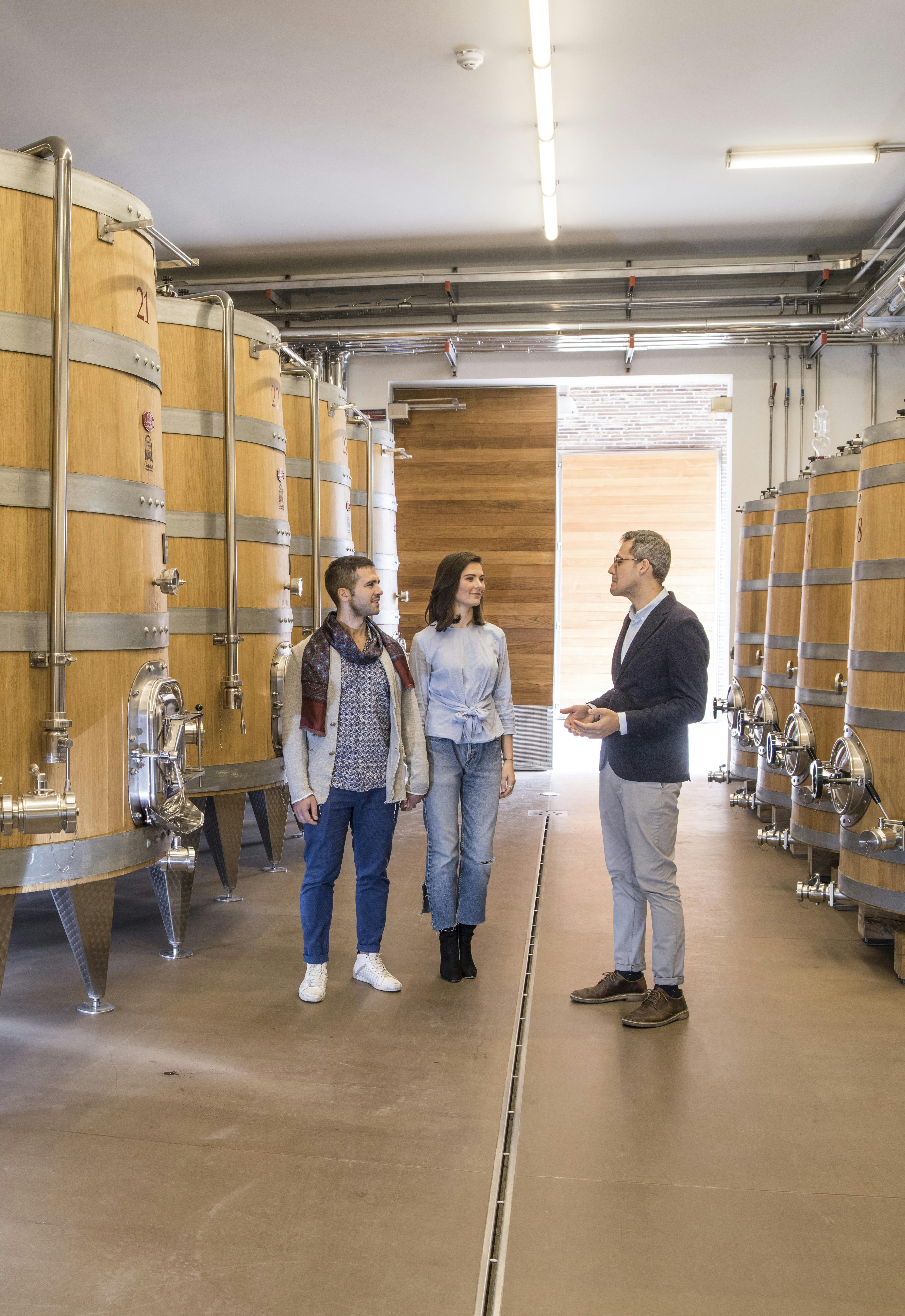 Hospitality-Il grande classico tour in the winery A couple visits the winery with big troncoconic wooden tanks