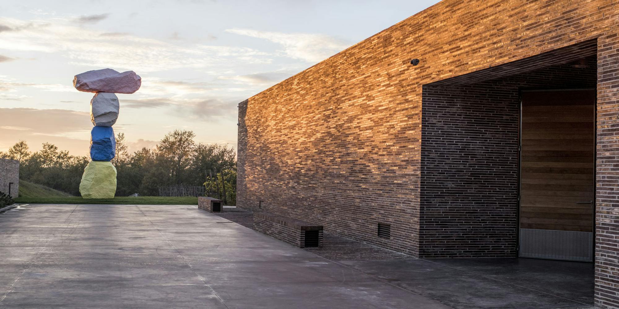 View sunset architecture winery rondinone View of the winery made of bricks at sunset with sculture of Ugo Rondinone