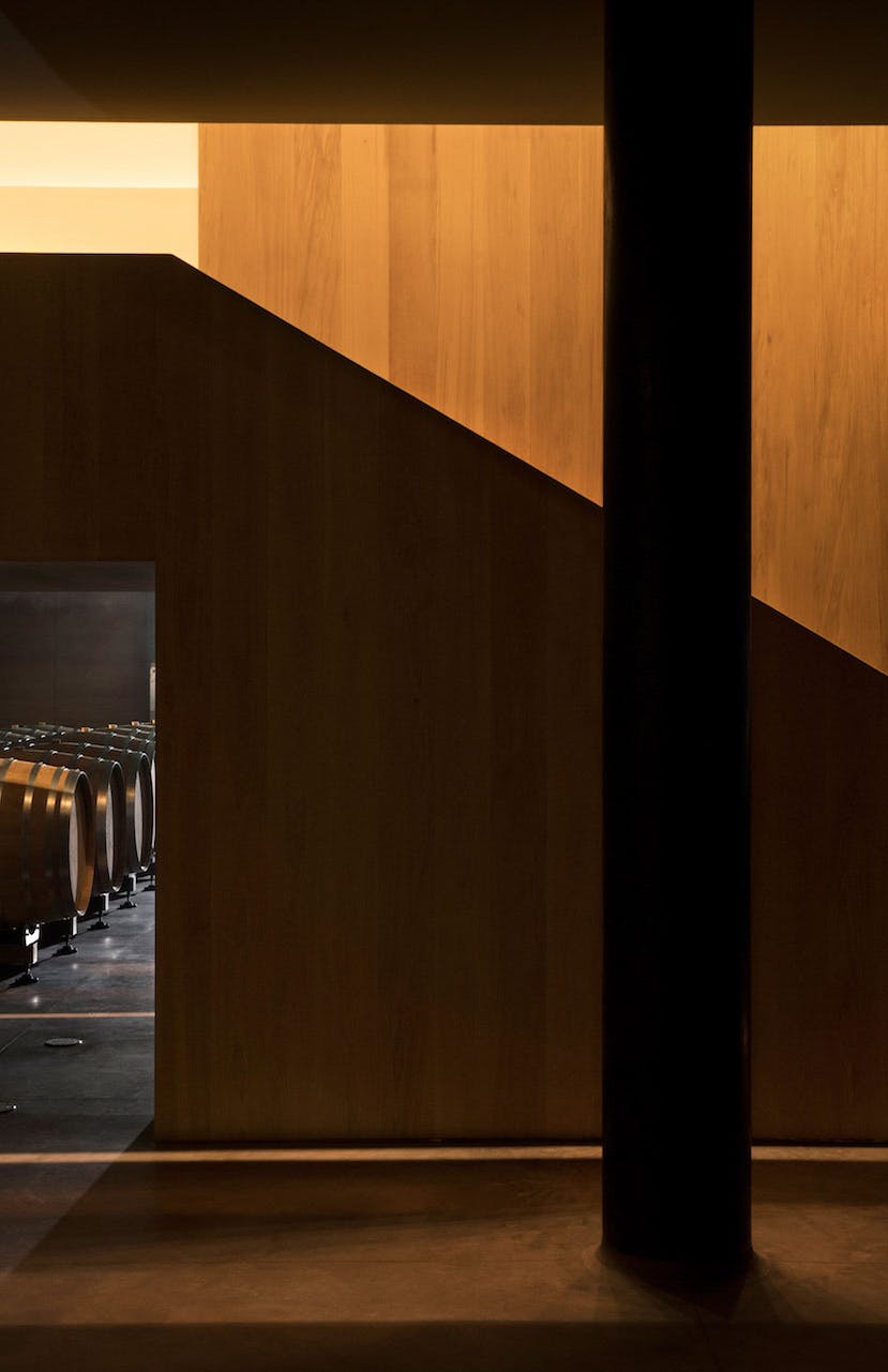 Architectural wooden staircase barrel room Architectural wooden staircase in the barrel room of the winery with some barrels in the background