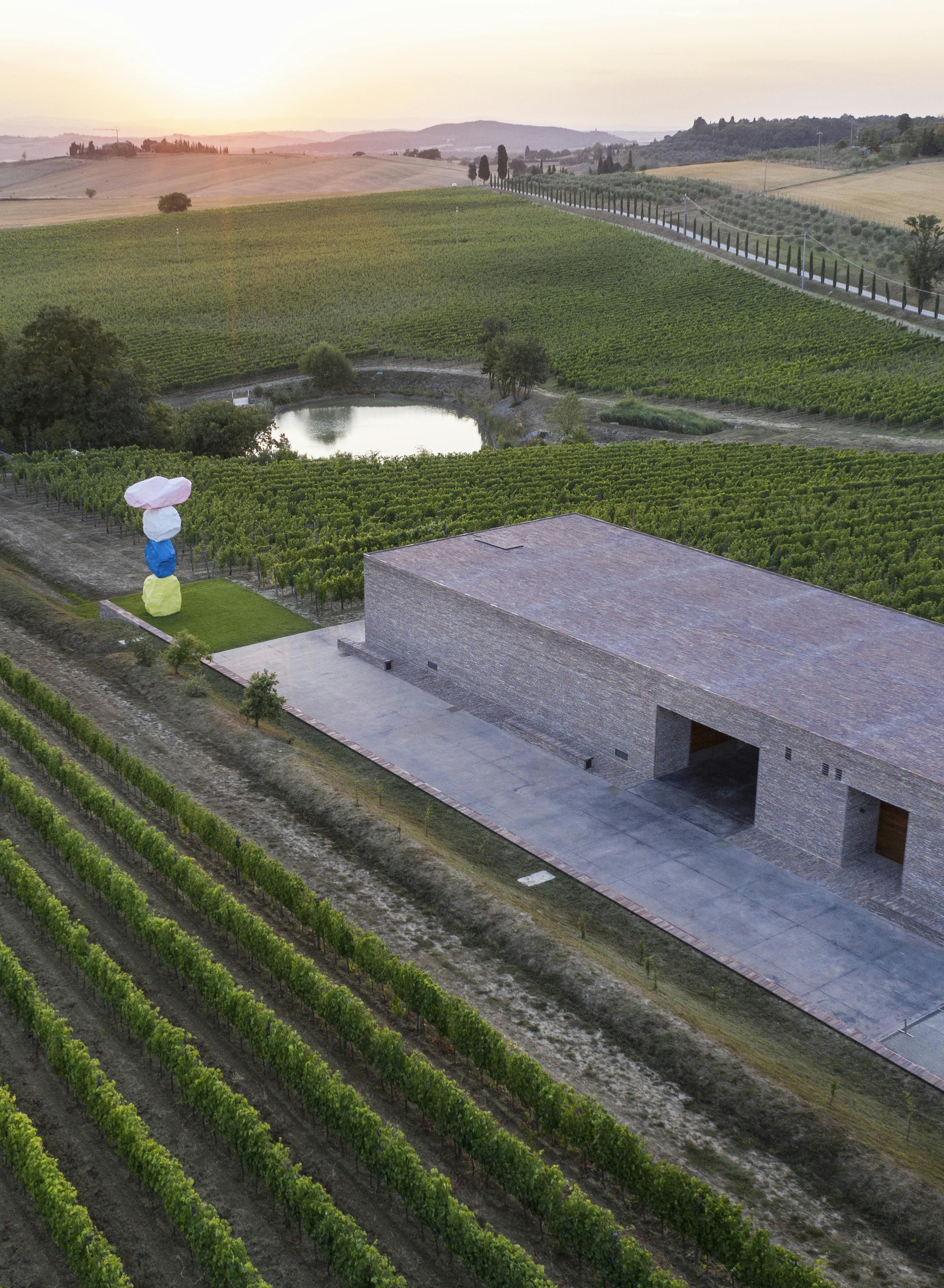 Aerial view drone winery vineyards Ugo Rondinone pienza Aerial view by drone of the winery with the sculpture of Ugo Rondinone, lake, vineyards and Pienza