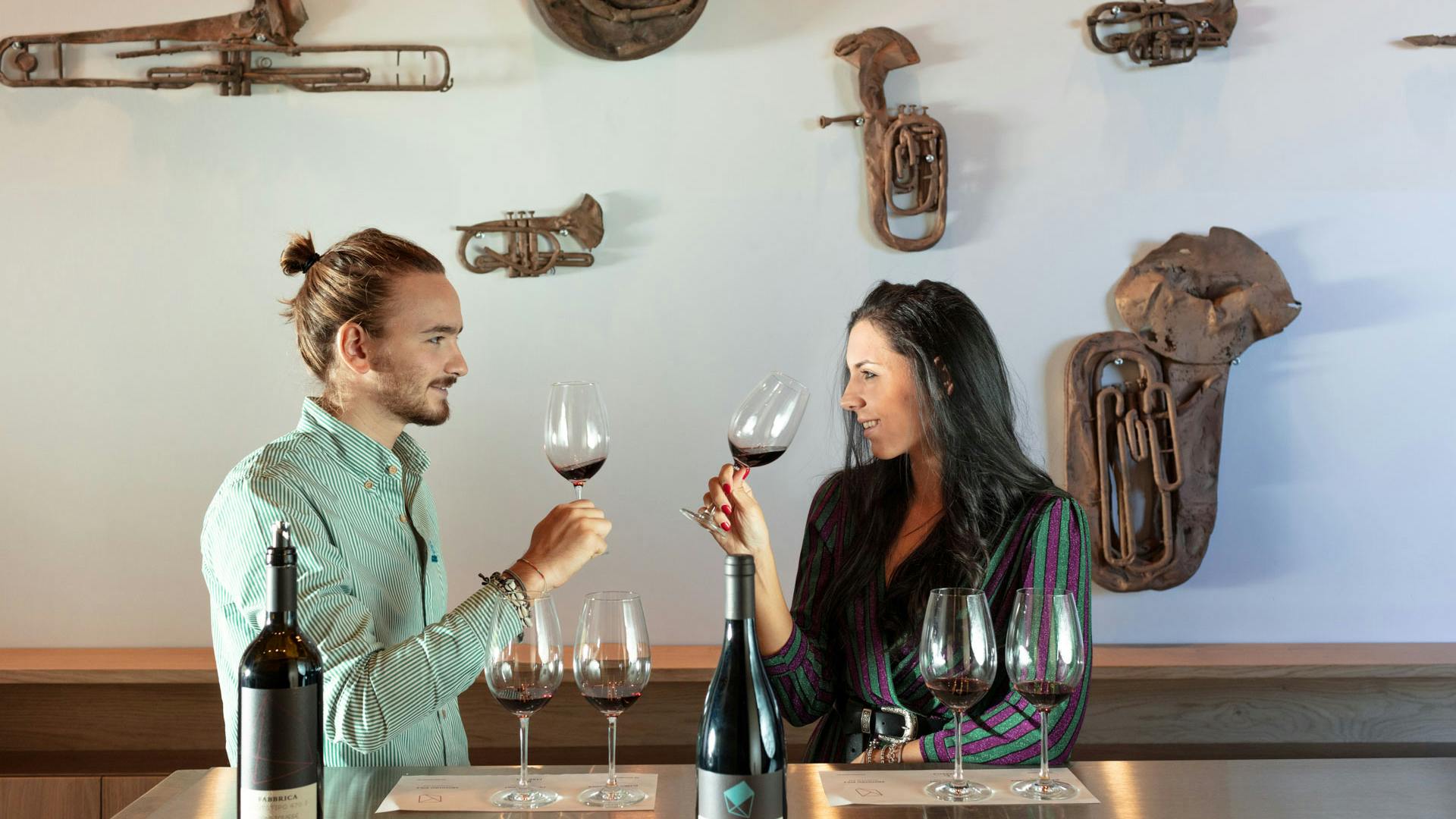 Tasting room bis A couple is tasting Fabbrica wines in the tasting room with sculptures of Valentin Carron in the background