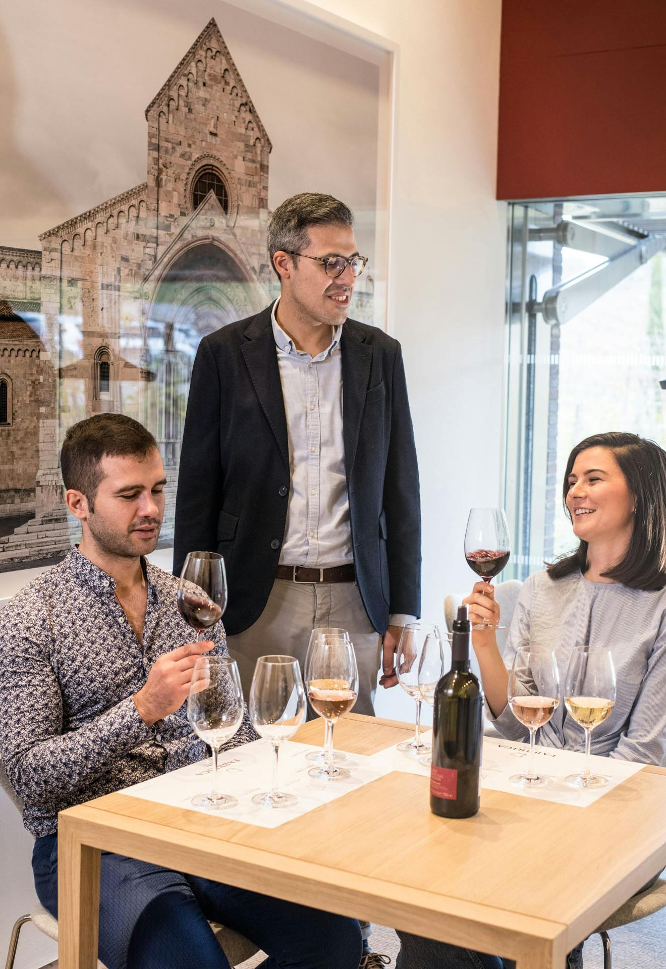 Sala degustazione bis markus brunetti Una coppia sta degustando i vini di fabbrica con una fotografia di Markus Brunetti sullo sfondo
