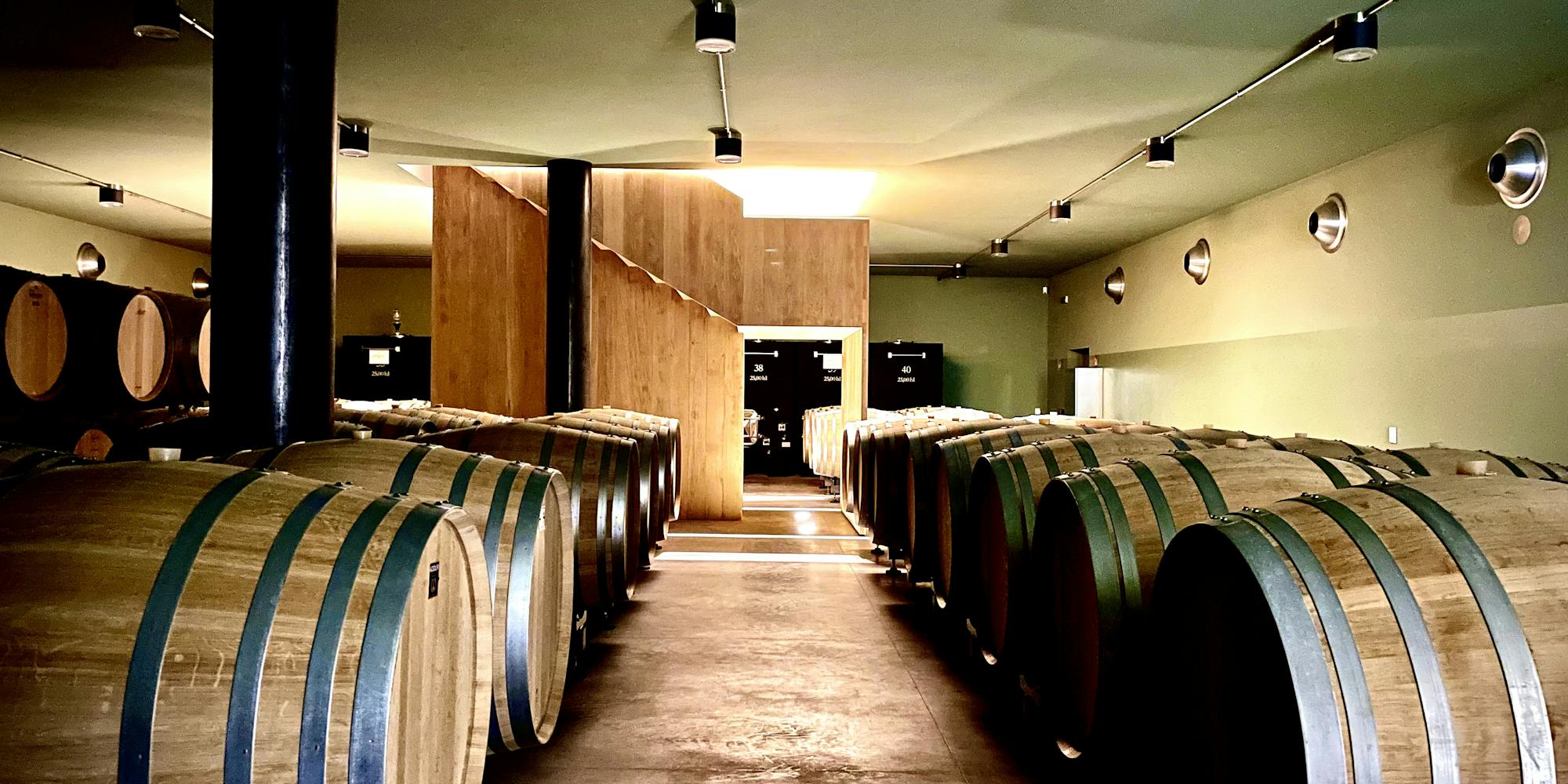 winery barrel room Barrels in the underground winery with the staircase in the background