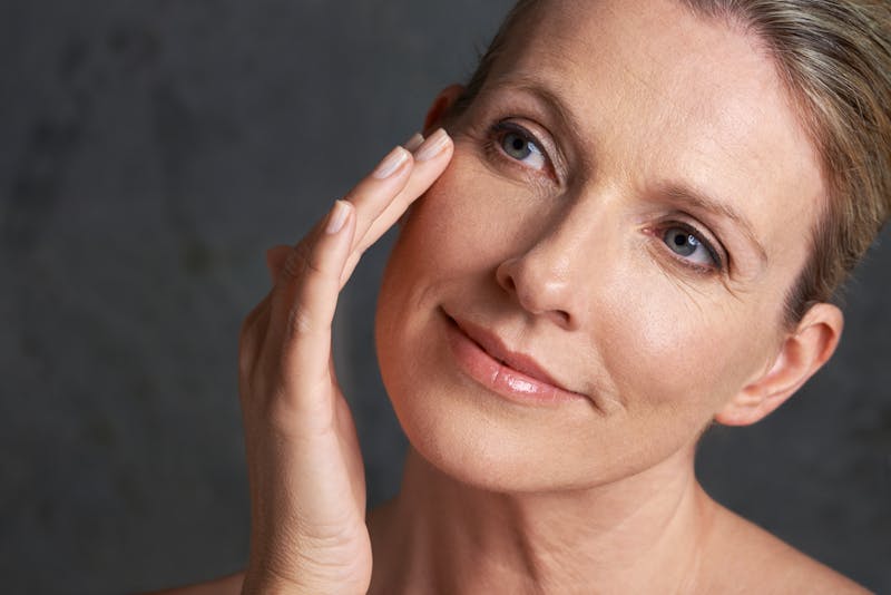 Older woman touching her face
