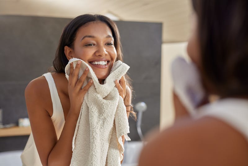woman cleaning her face with a towel