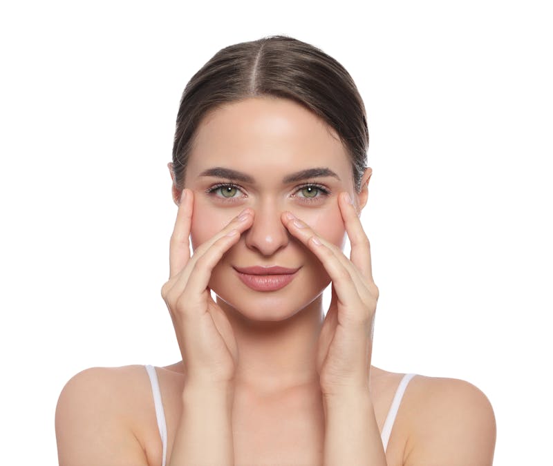 woman lightly touching her under eye area