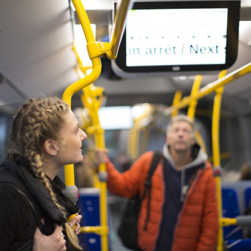 A man and a woman standing in a bus