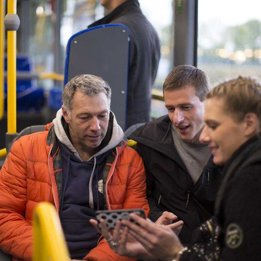 Passagers de bus qui consultent le trajet en temps réel sur leur téléphone portable