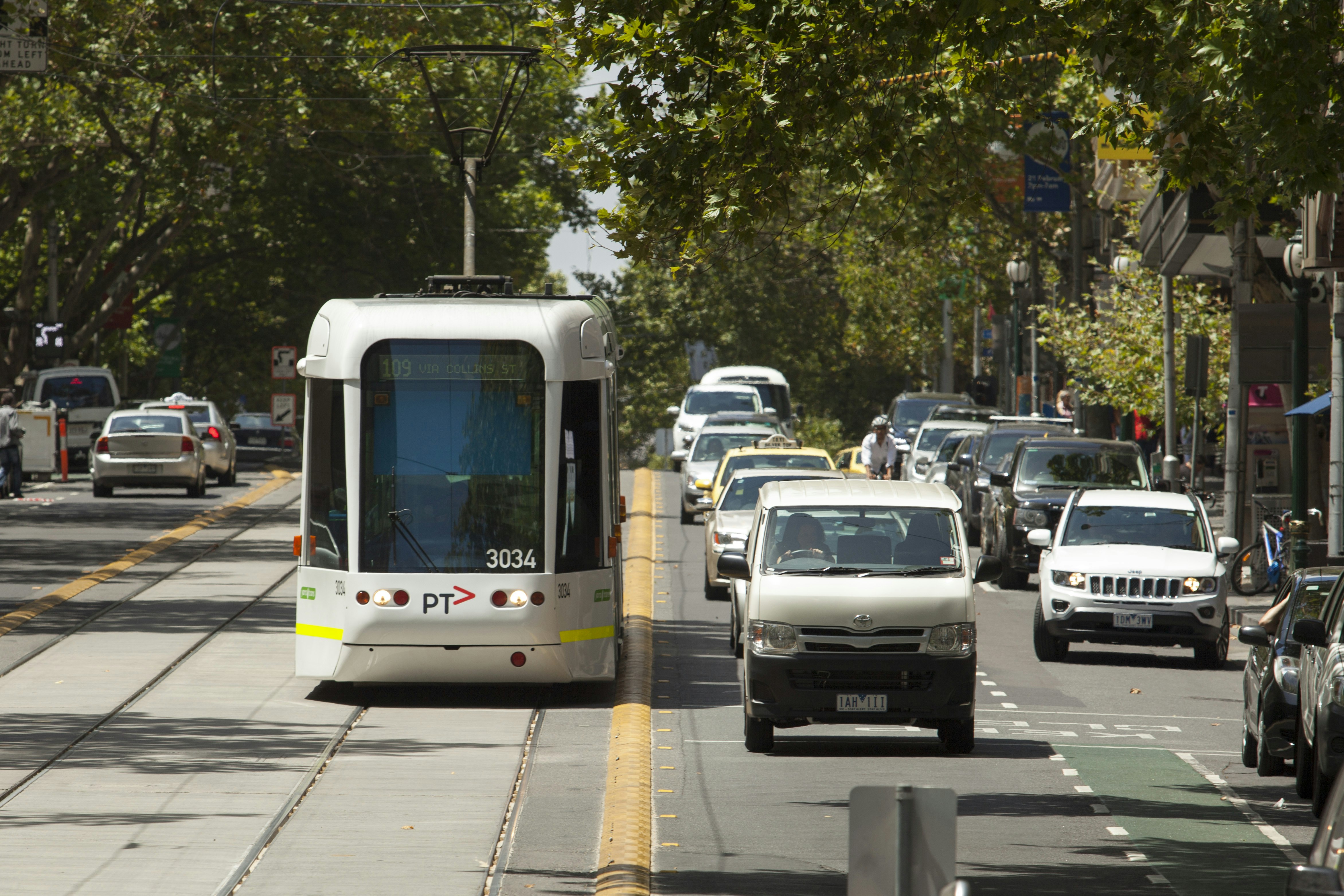 Yarra Trams running next to a road with cars