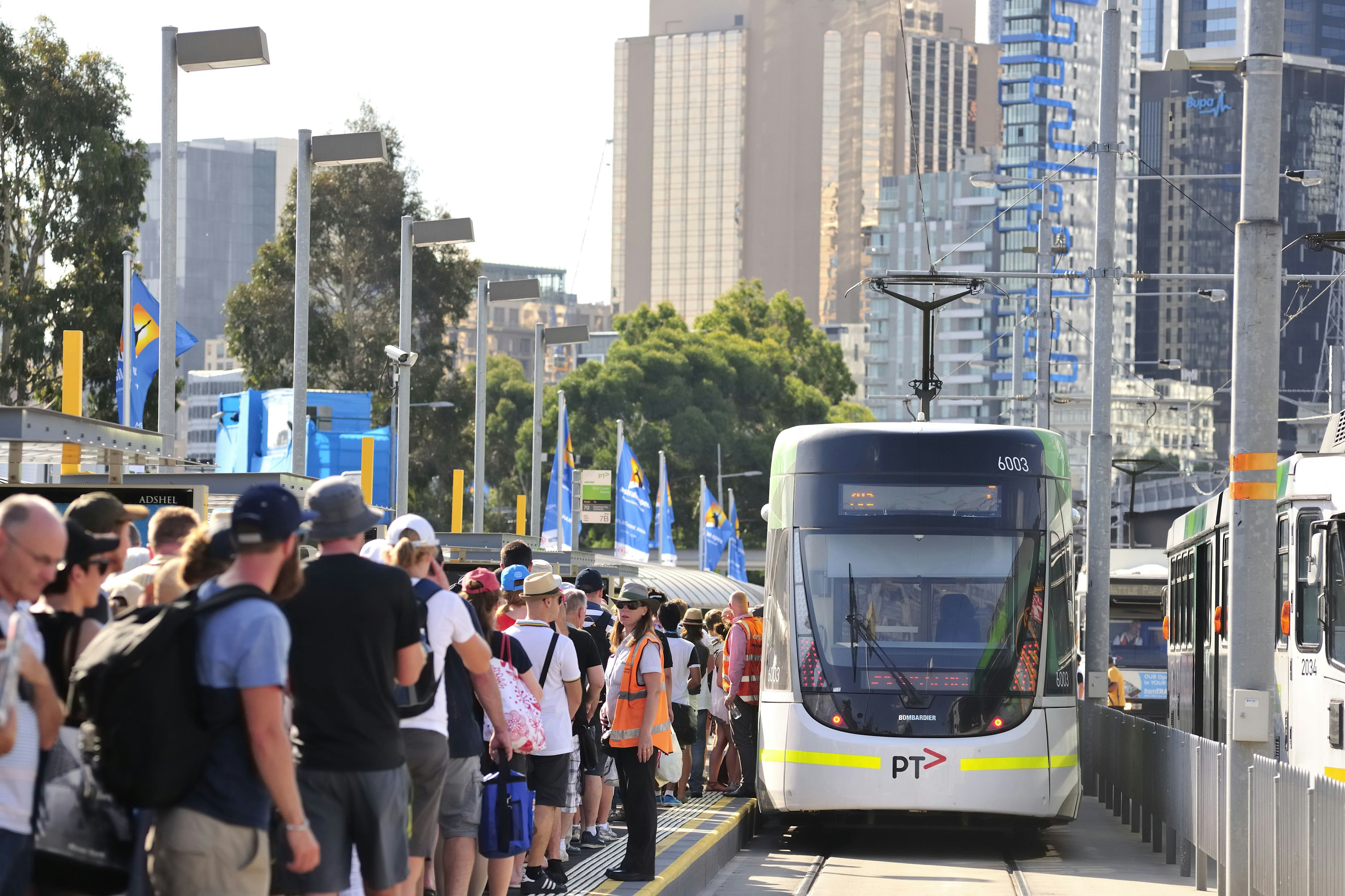 Des passagers font la queue sur le quai pour monter dans un tramway Yarra Trams