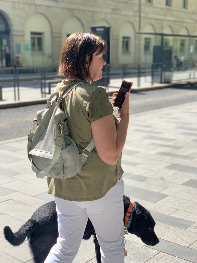 Visually impaired person with a guide dog using the Easymob application